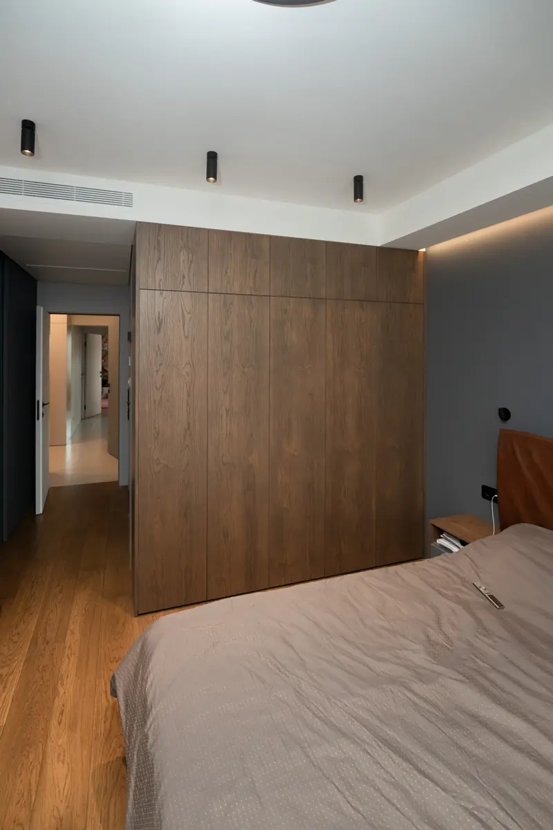 Темный шкаф в современной спальне
