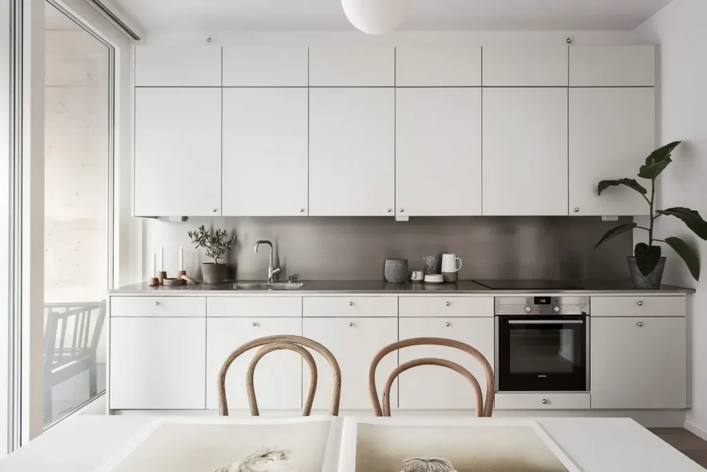 Белая кухня с мини-антресолями в строгом стиле и без стены на балкон