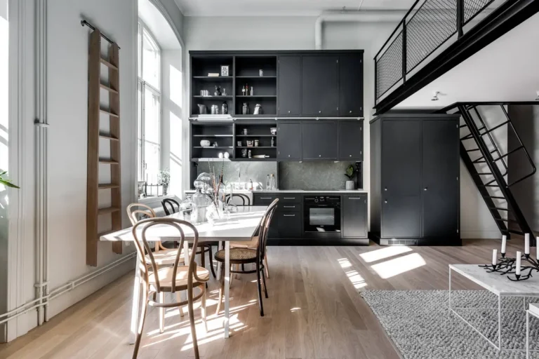 Черная кухня-гостиная с антресолями и приставной лестницей в 2-х-ярусном лофте