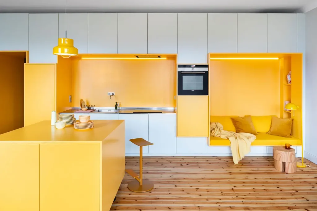 Кухня-гостиная в стиле модерн с деревянным полом, белыми фасадами и желтой покраской по месту