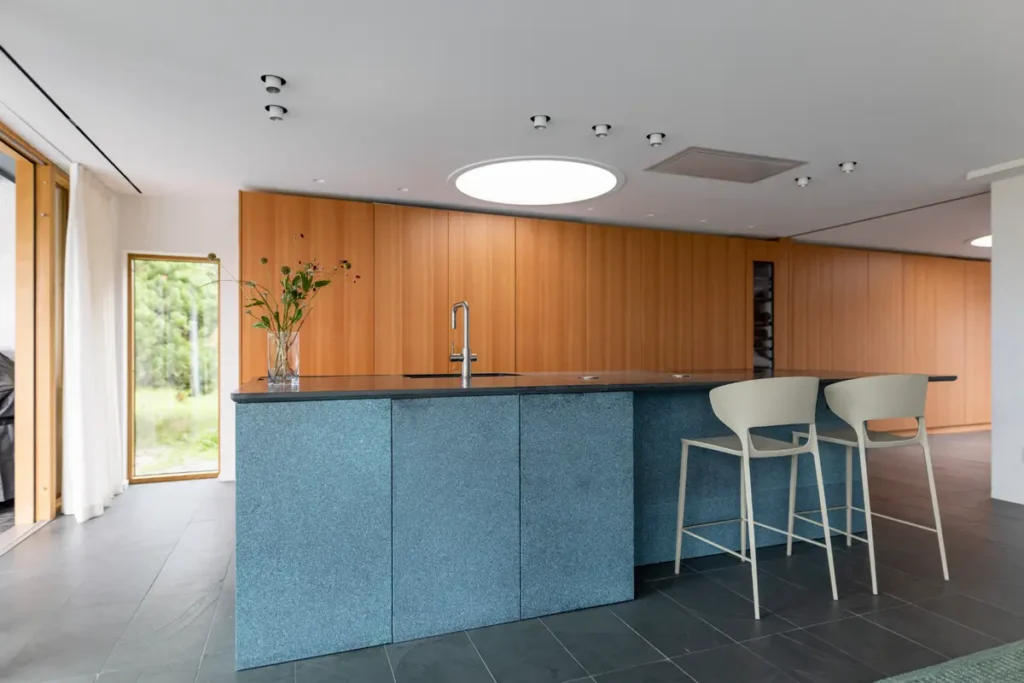 Кухня-модерн с островом в цвете синего песка и с длинным рядом высоких шкафов в цвете яркой вишни