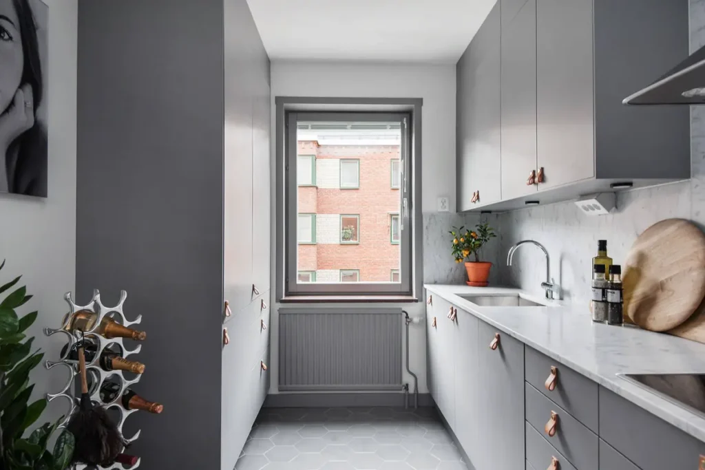 Прямая кухня в 2 линии под потолок с серыми фасадами и кожаными ручками