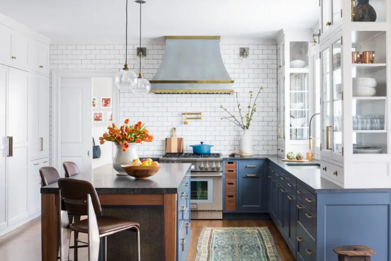 Синяя кухня с 2-мя белыми шкафами-сервантами и кастомной вытяжкой из металла с грубой обработкой