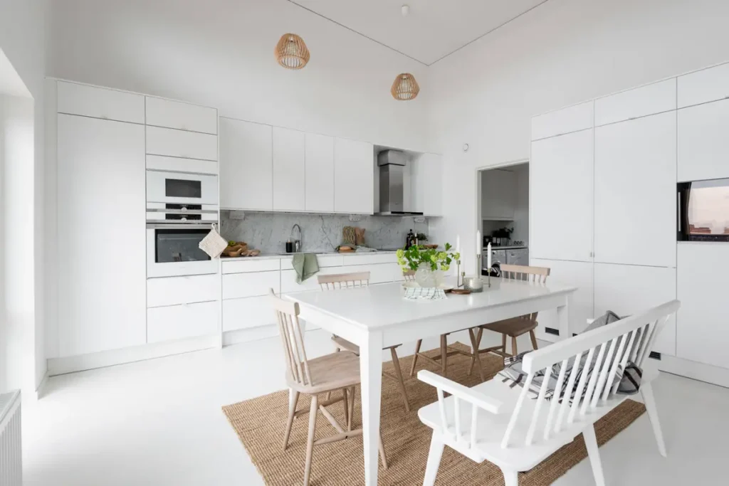 Скандинавская встроенная кухня в едином белом цвете и мини-ручками на плоских фасадах