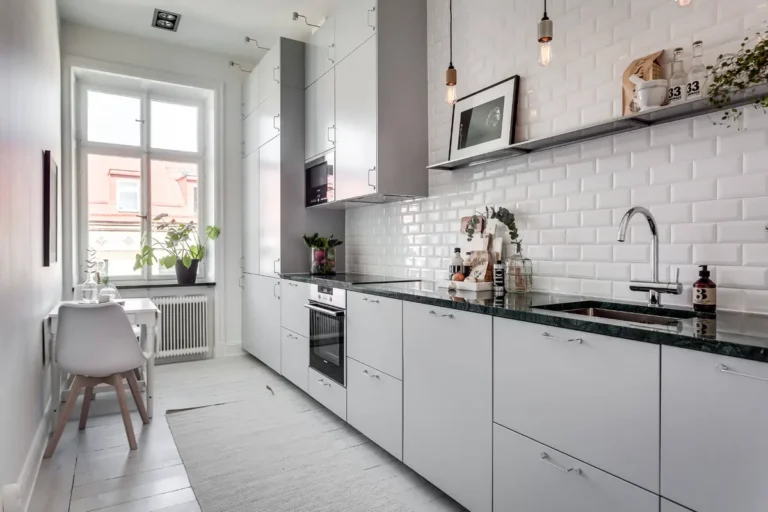 Светло-серая вытянутая кухня с антресолями в скромном белом скандинавском интерьере