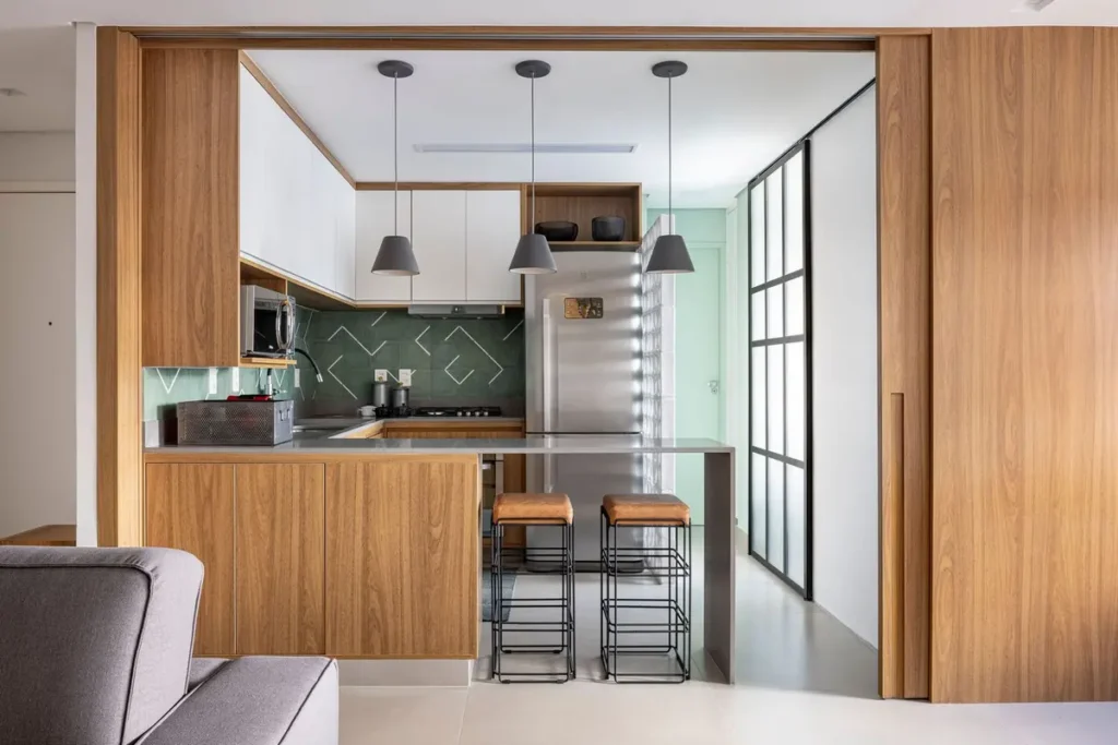 Встроенная под потолок угловая кухня-модерн с полуостровом в нише за широкими раздвижными дверьми