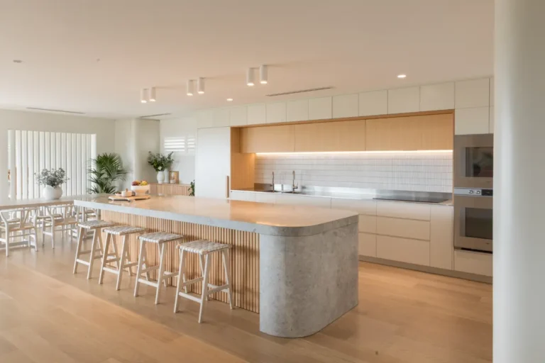 Кухня-гостиная в стиле скандинавского минимализма с антресолями, большим радиусным островом с деревянными рейками