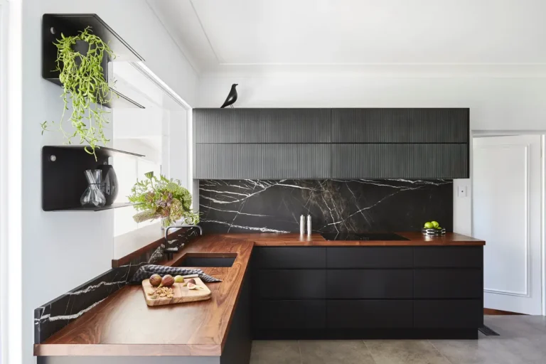 Угловая кухня с черными фасадами без ручек и столешницей из американского ореха